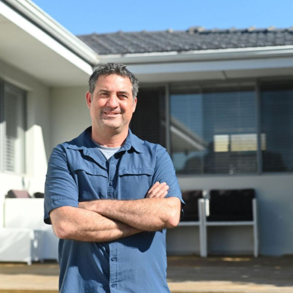 confident home owner in front of a house